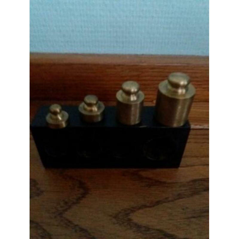 Houten blokje met 4 koperen gewichten in beukenhoutenblokje.