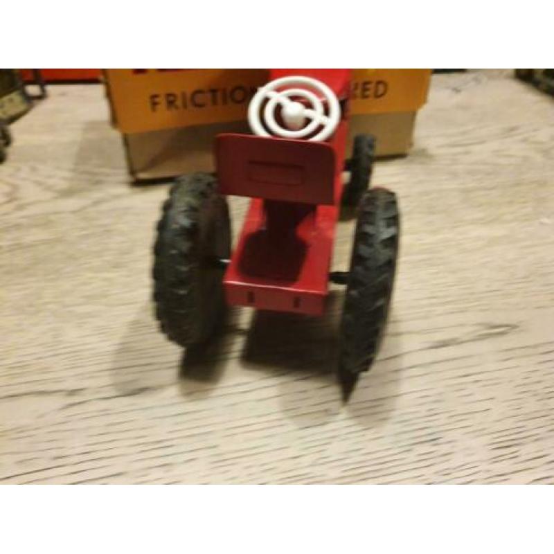 Oude blikken tractor met doos japan